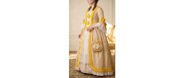 Femme portant la robe de prestige Marie-Antoinette, Souveraine de Trianon jaune et or, boutique de location Be Happy.