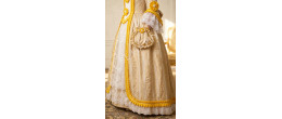 Femme portant la robe de prestige Marie-Antoinette, Souveraine de Trianon jaune et or, boutique de location Be Happy.