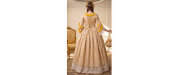 Femme portant la robe de prestige Marie-Antoinette, Souveraine de Trianon jaune et or, boutique de location Be Happy.