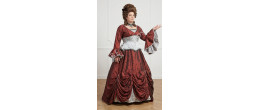 Femme portant la robe de comtesse Hortense de Roche-Brune rouge et grise avec corset et manches évasées, boutique Be Happy.